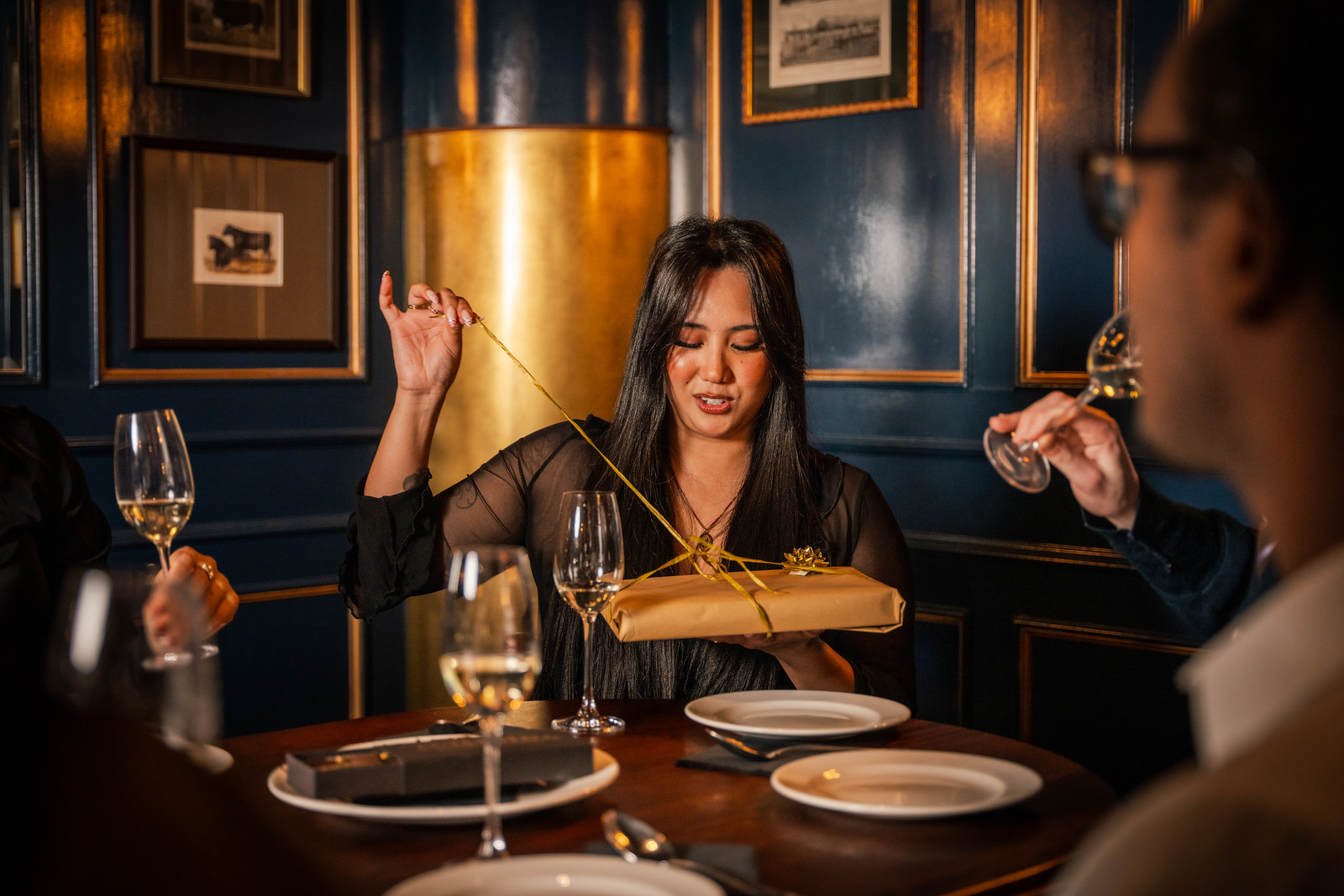 Proper Celebrations at Hawkmoor Dublin 1 A dark haired woman pulling a ribbon on a gift